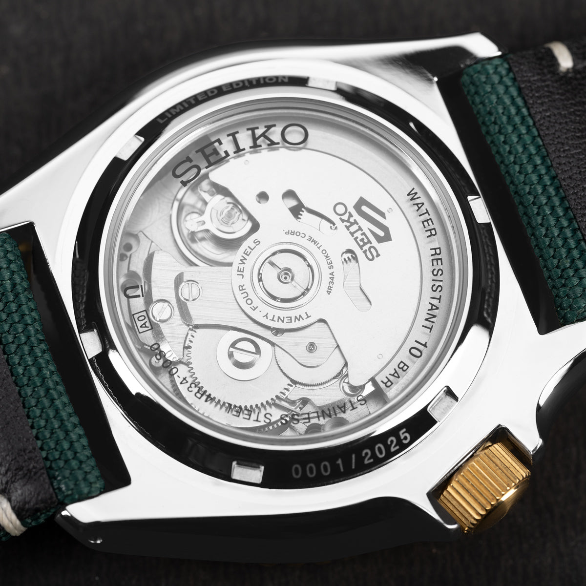 Transparent case back of the Seiko 5 Sports Forest Green Sunrise GMT, showcasing the automatic mechanical movement, Caliber 4R34